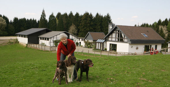 Susanne Ottofülling mit drei Hunden vor dem Hof des Hundehotels Welzerberg
